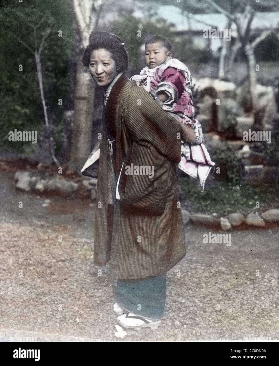 [ 1900s Japan - Japanese Mother and Child ] — A mother with her child on her back, a custom known as onbu (負んぶ).  20th century vintage glass slide. Stock Photo
