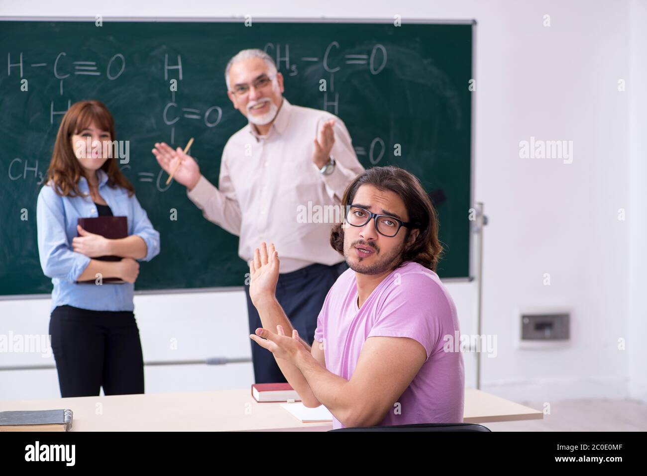Old teacher and two students in the classroom Stock Photo - Alamy