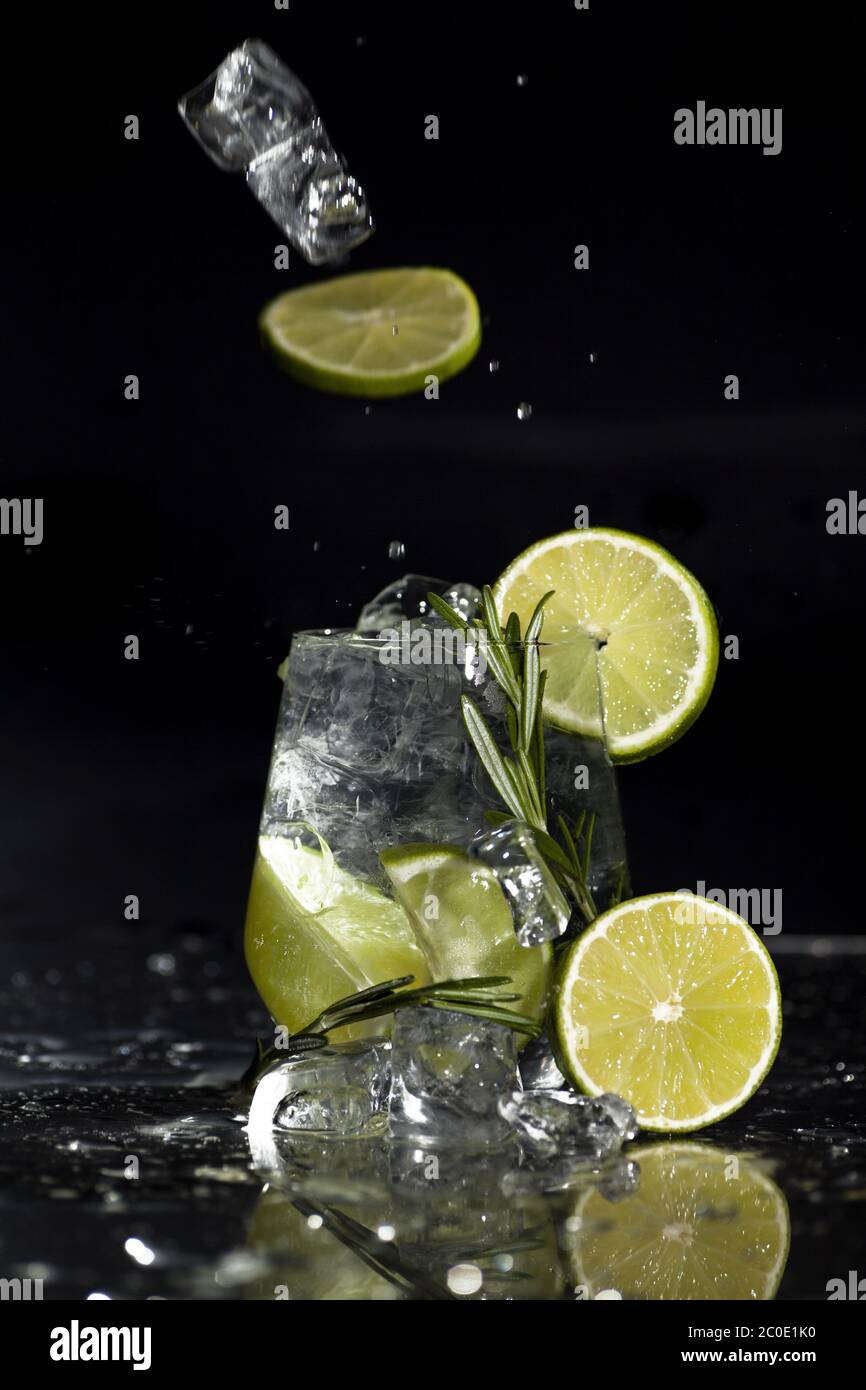 Gin and tonic cocktail with lime over black background. Stock Photo