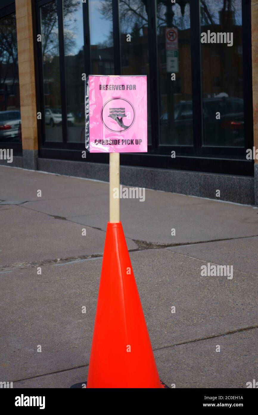 Sign in an orange street warning cone for reserved parking and picking up restaurant food maintaining social distancing. St Paul Minnesota MN USA Stock Photo