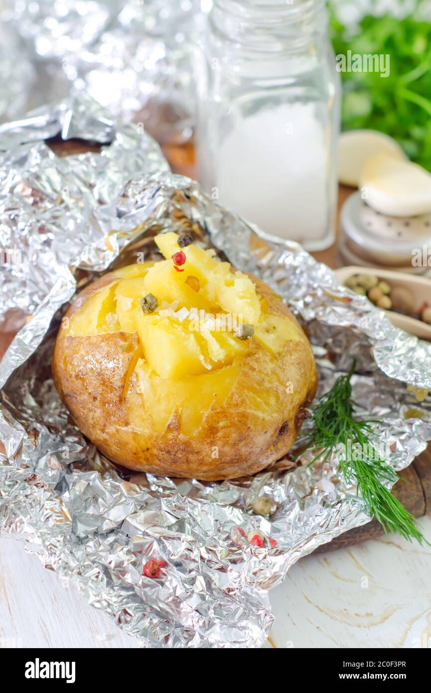 baked potato in foil Stock Photo Alamy