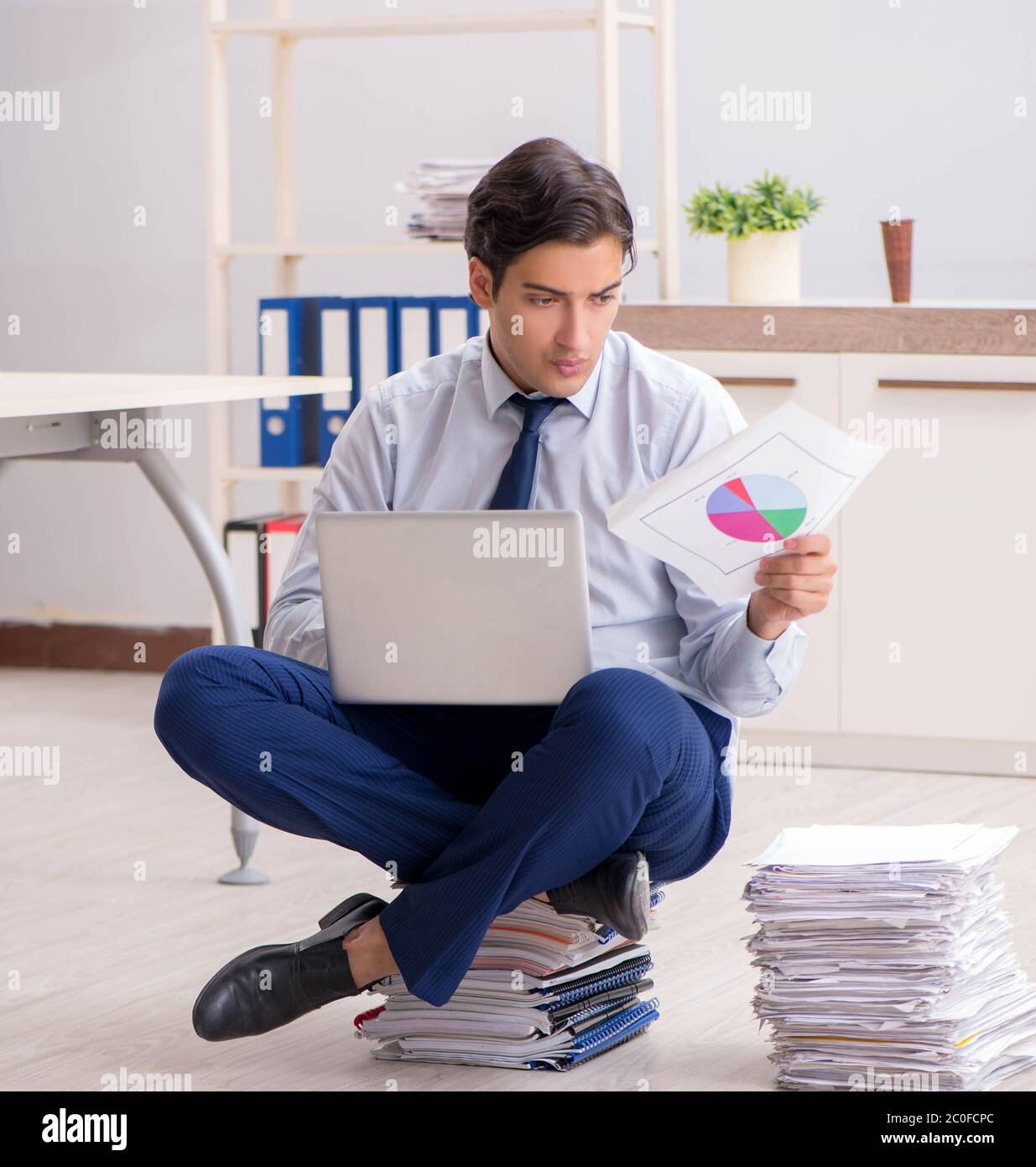 The extremely busy employee working in the office Stock Photo