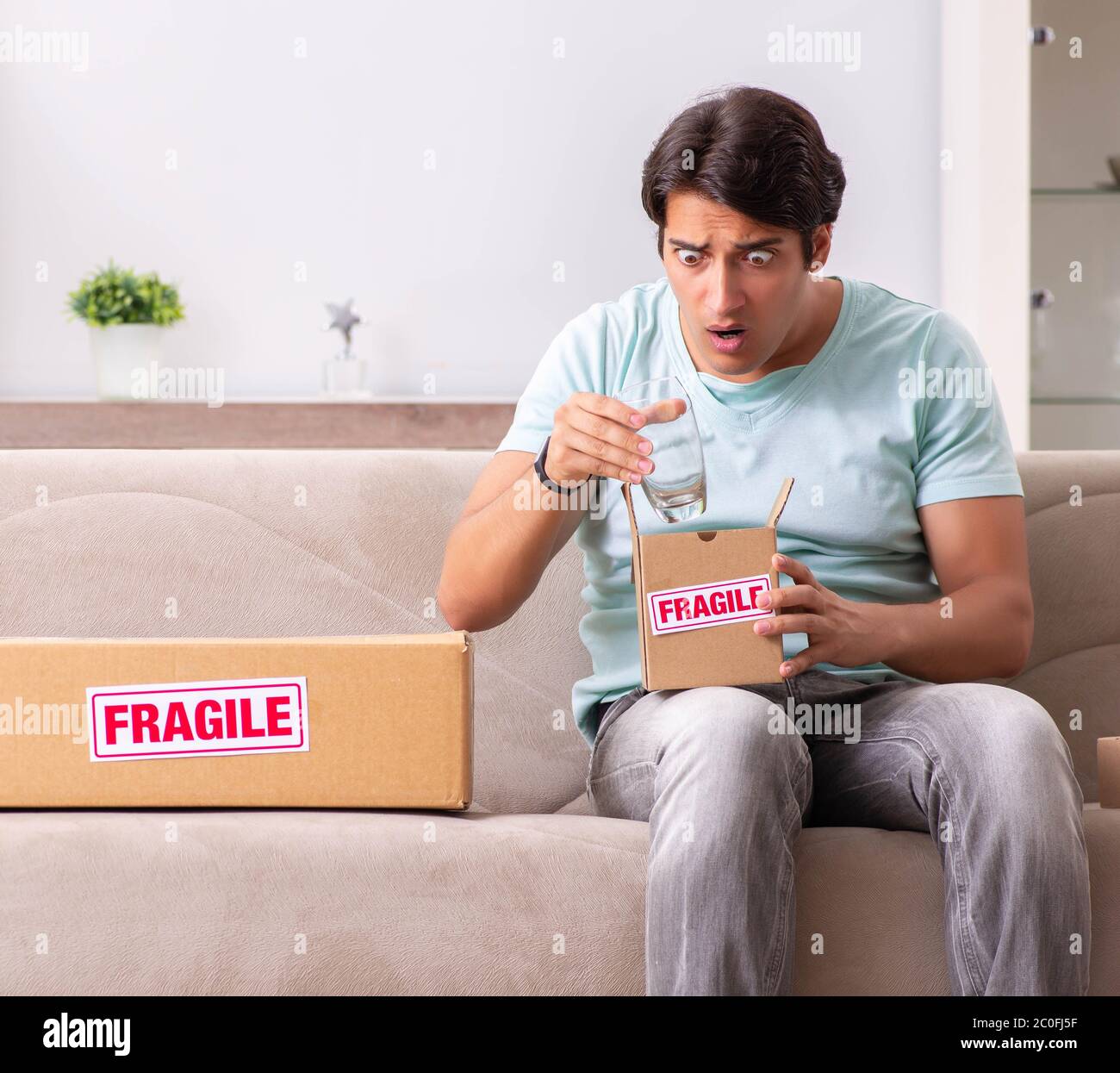 The man opening fragile parcel ordered from internet Stock Photo - Alamy