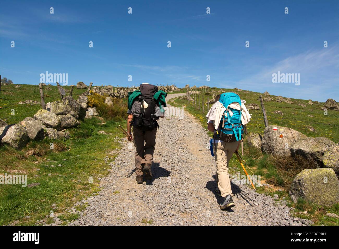 Pilgrims on footpath of Via Podiensis or Chemin de St-Jacques on French Way of St. James, Aveyron department, Occitanie, France Stock Photo