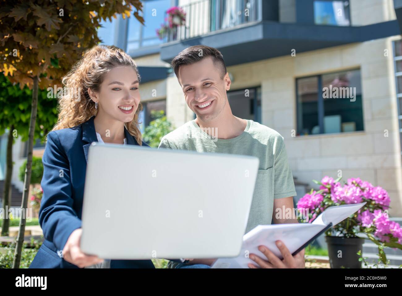 Female broker offering variants for apartment rent to the client Stock Photo