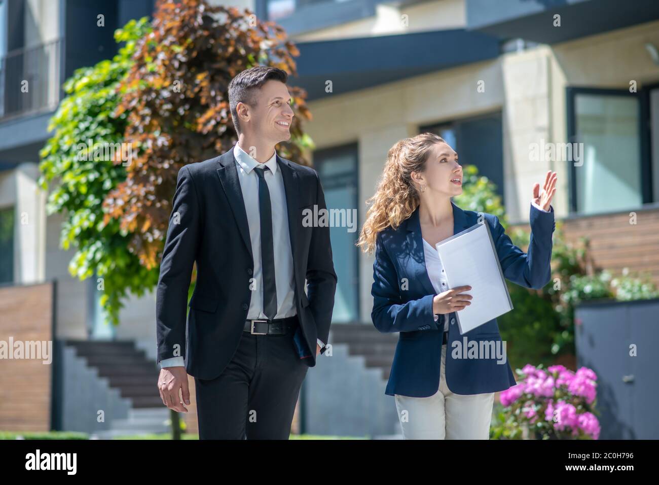 Female broker showing houses with apartments for rent to the client Stock Photo