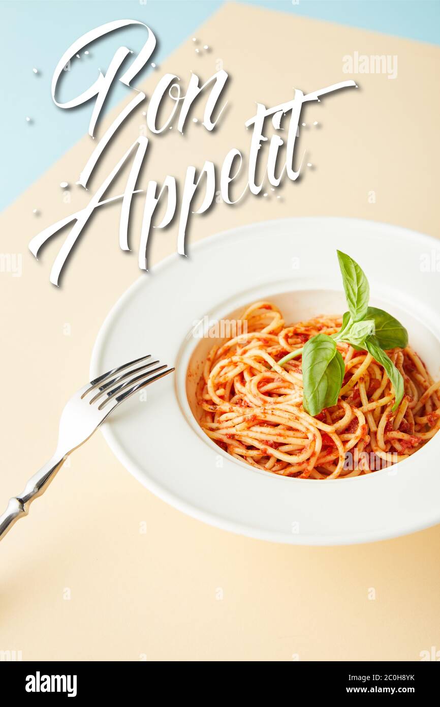 delicious spaghetti with tomato sauce in plate near fork on blue and yellow  background with bon appetit illustration Stock Photo - Alamy