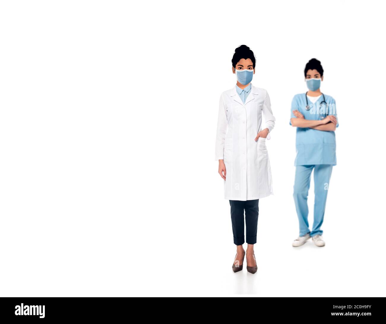 selective focus of african american nurse and doctor with illustrated faces in medical masks on white Stock Photo