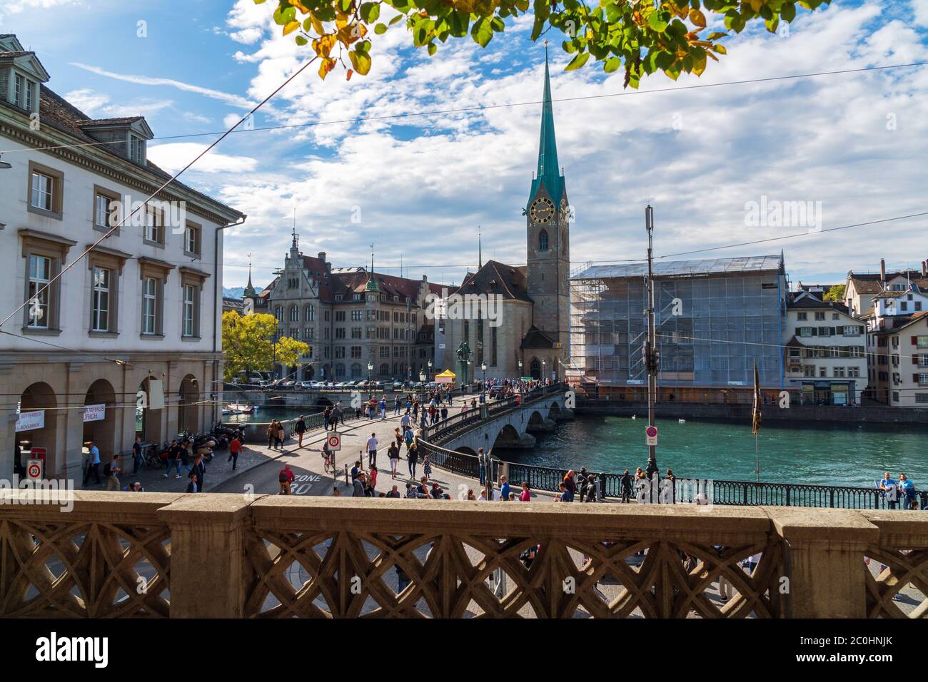 Zurich, Switzerland - October 6, 2018: View on church Fraumünster. People are visiting sights and walking over the bridge Münsterbrücke across a river. Stock Photo