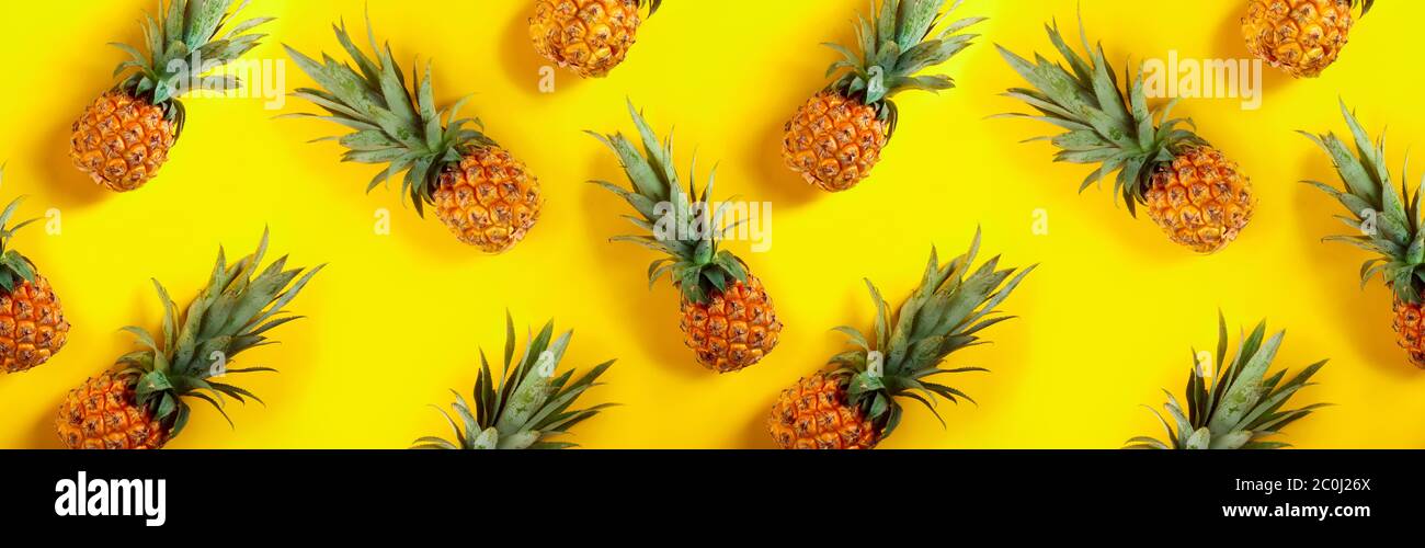 Seamless horizontal texture, pineapples on a yellow background. Stock Photo
