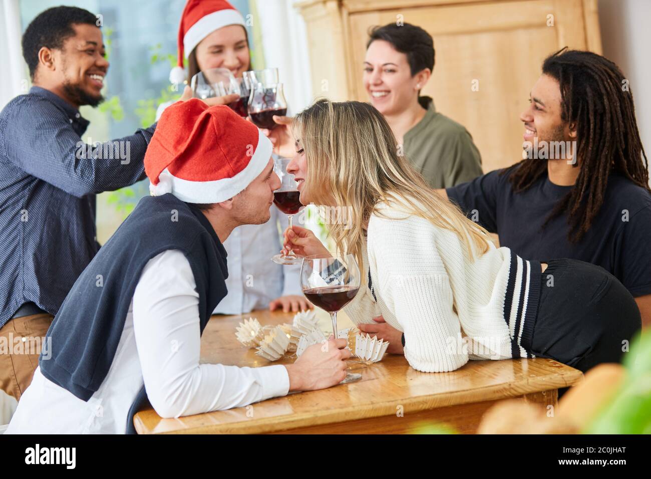 Two colleagues kiss at a Christmas party in the office before Christmas Stock Photo