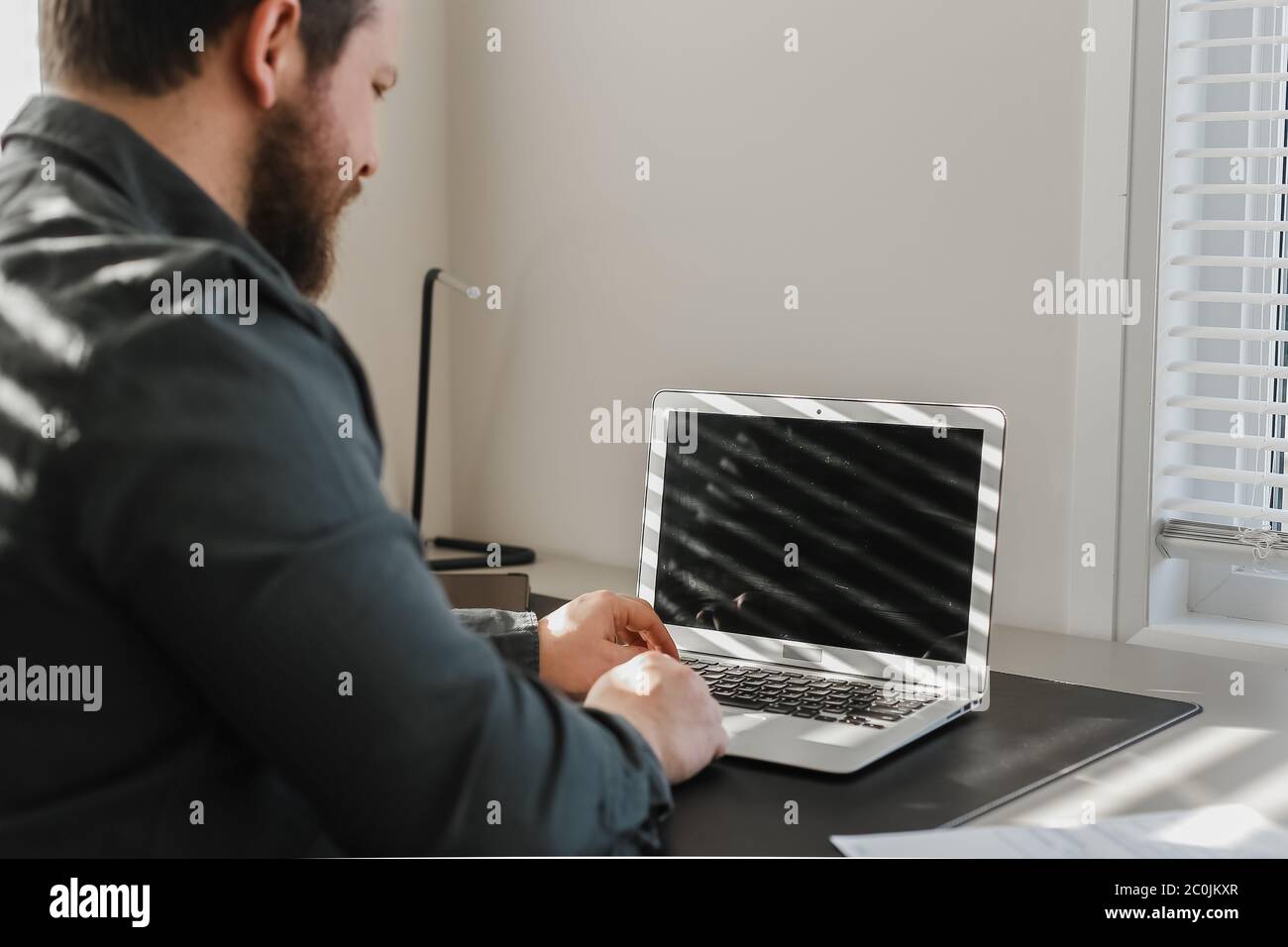 Male programmer writing program at office on laptop, typing on keyboard. Stock Photo