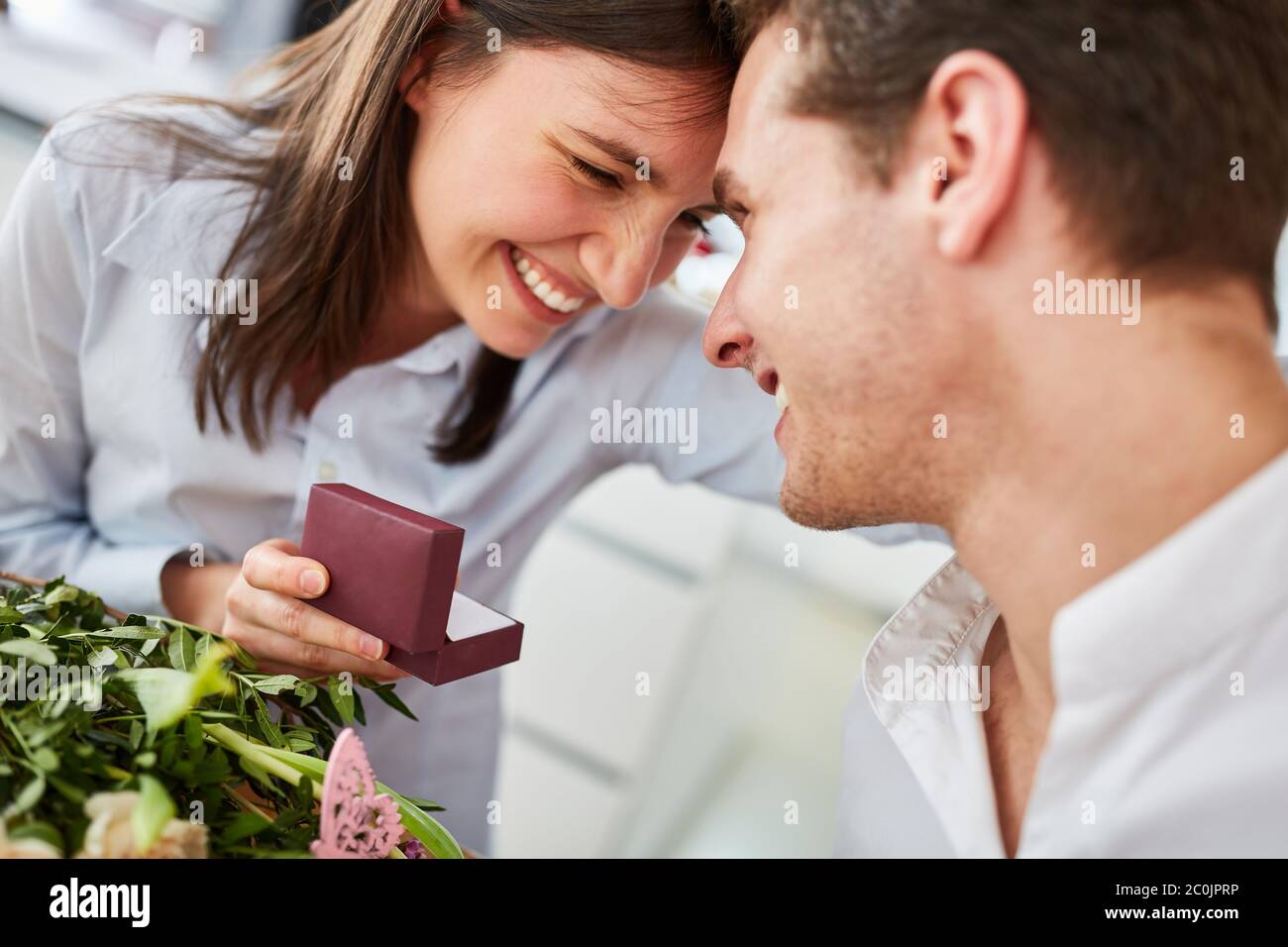 Happy woman holding box with engagement ring after request from man on Valentine's Day Stock Photo