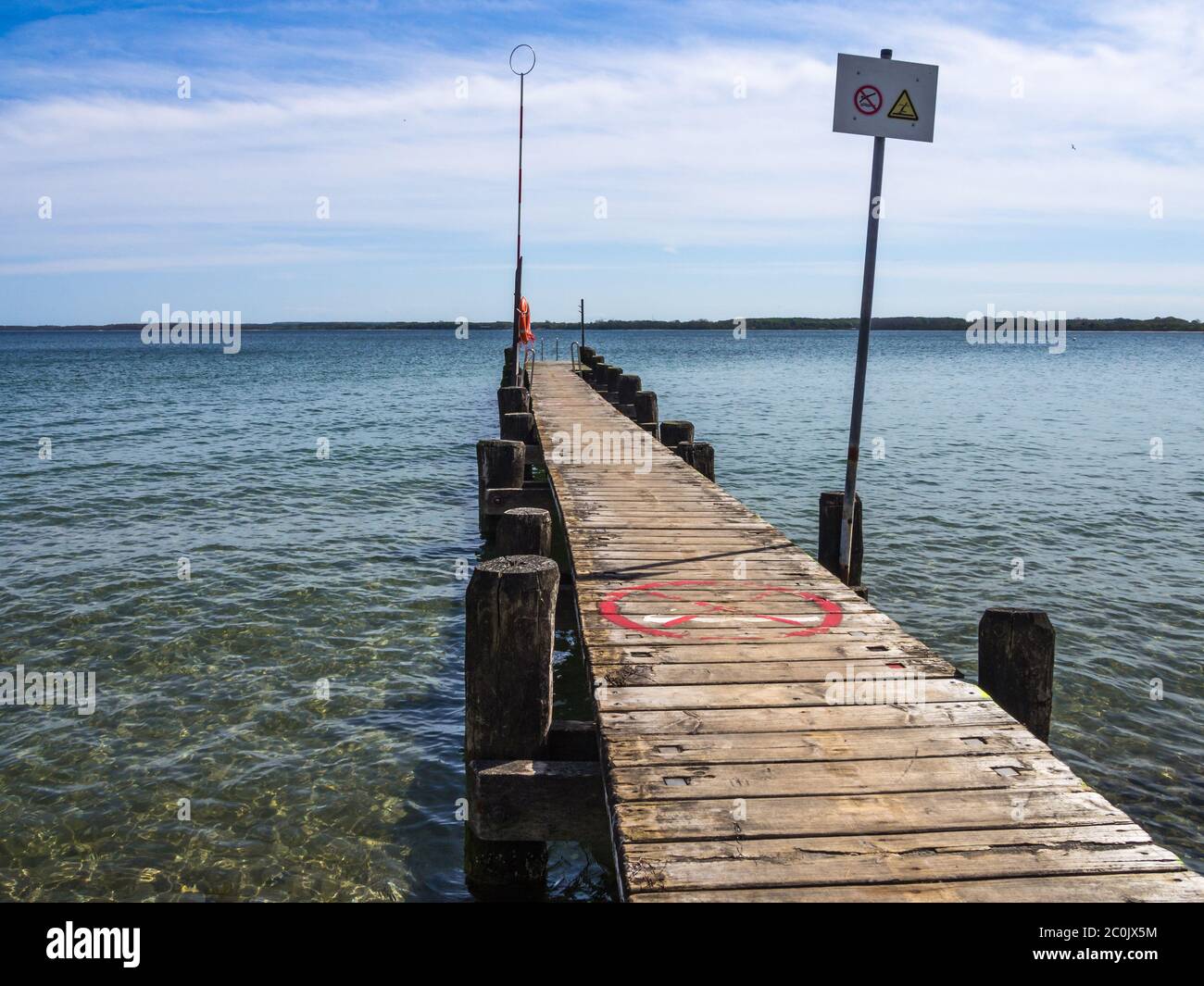 wooden boat landing stage with rescue ring and rescue pole Stock Photo