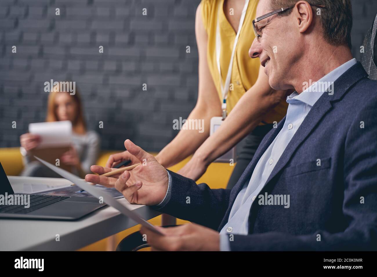 Handsome mature man talking to his assistant Stock Photo