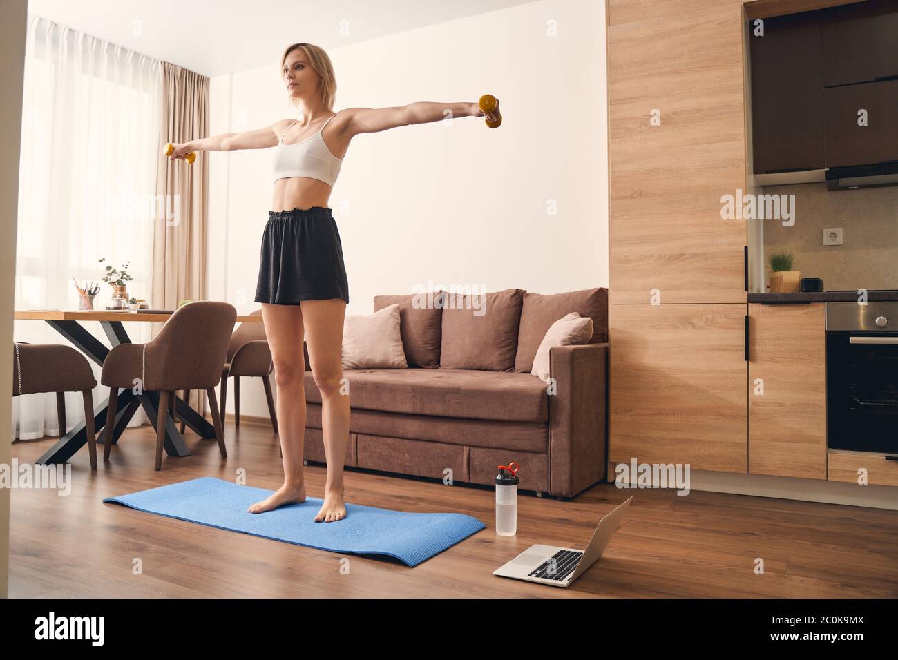 Fit lady doing an exercise with weights Stock Photo