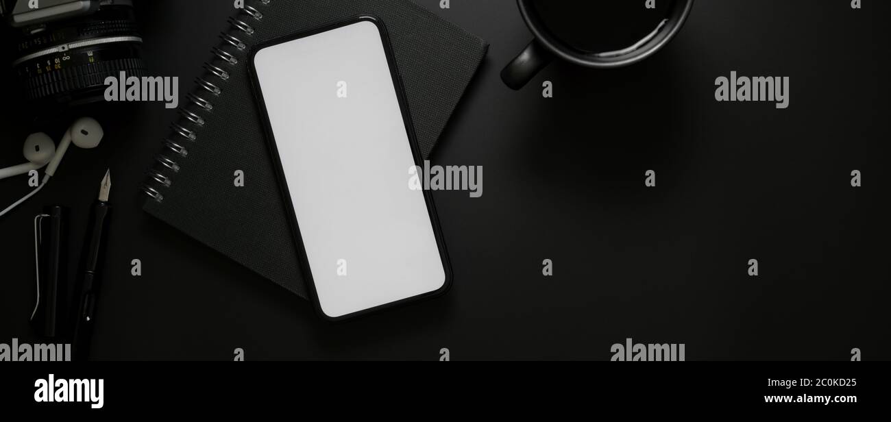 Top view of blank screen smartphone above black notebook and coffee cup ...