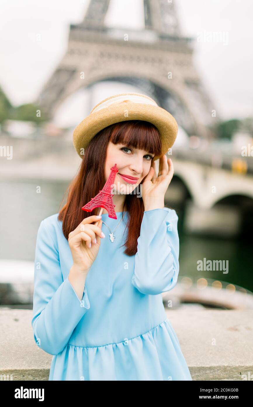 Pretty young girl with red lipstick wearing straw hat and blue dress ...
