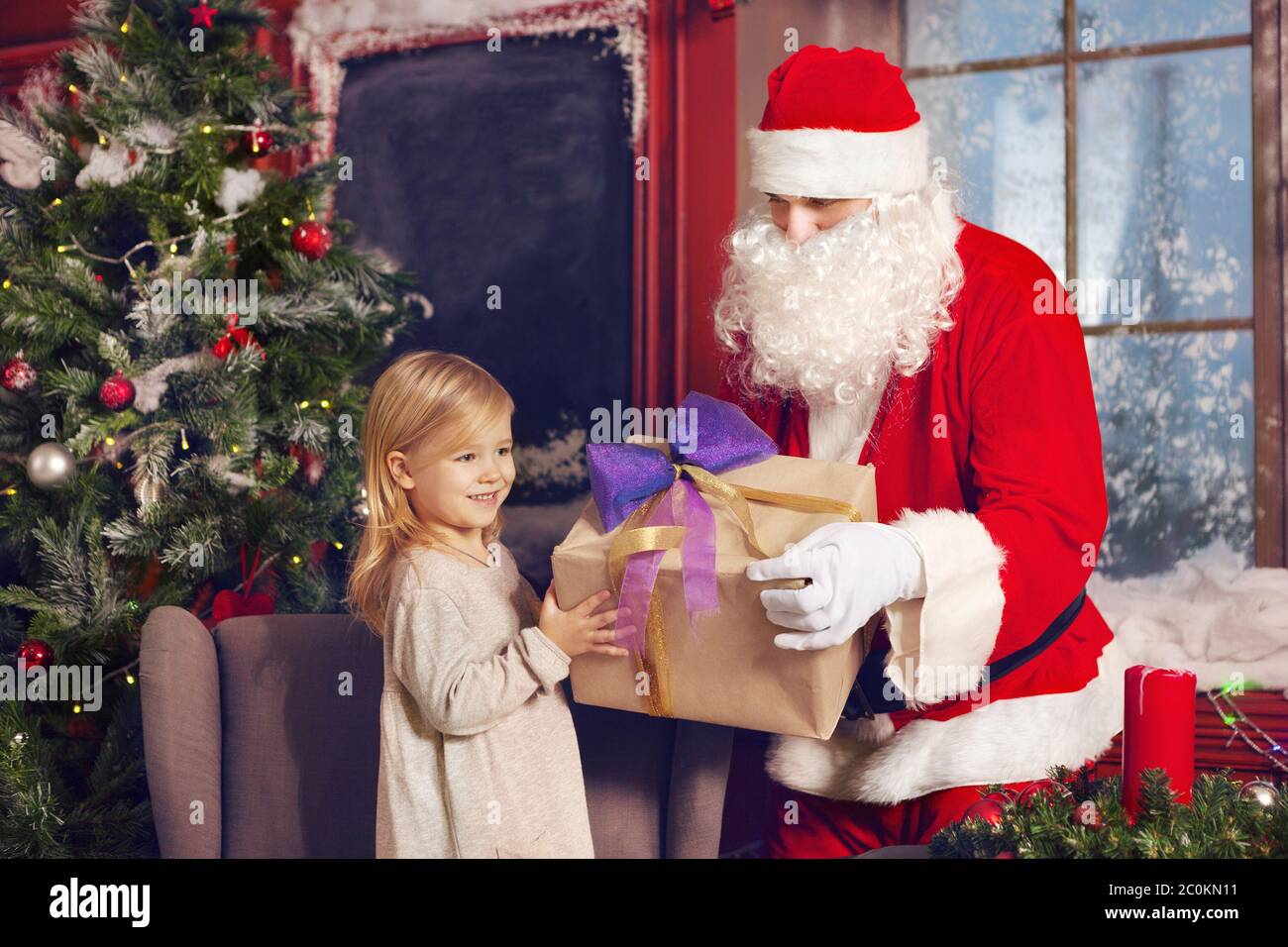 Smiling little girl with Santa Claus and gifts Stock Photo
