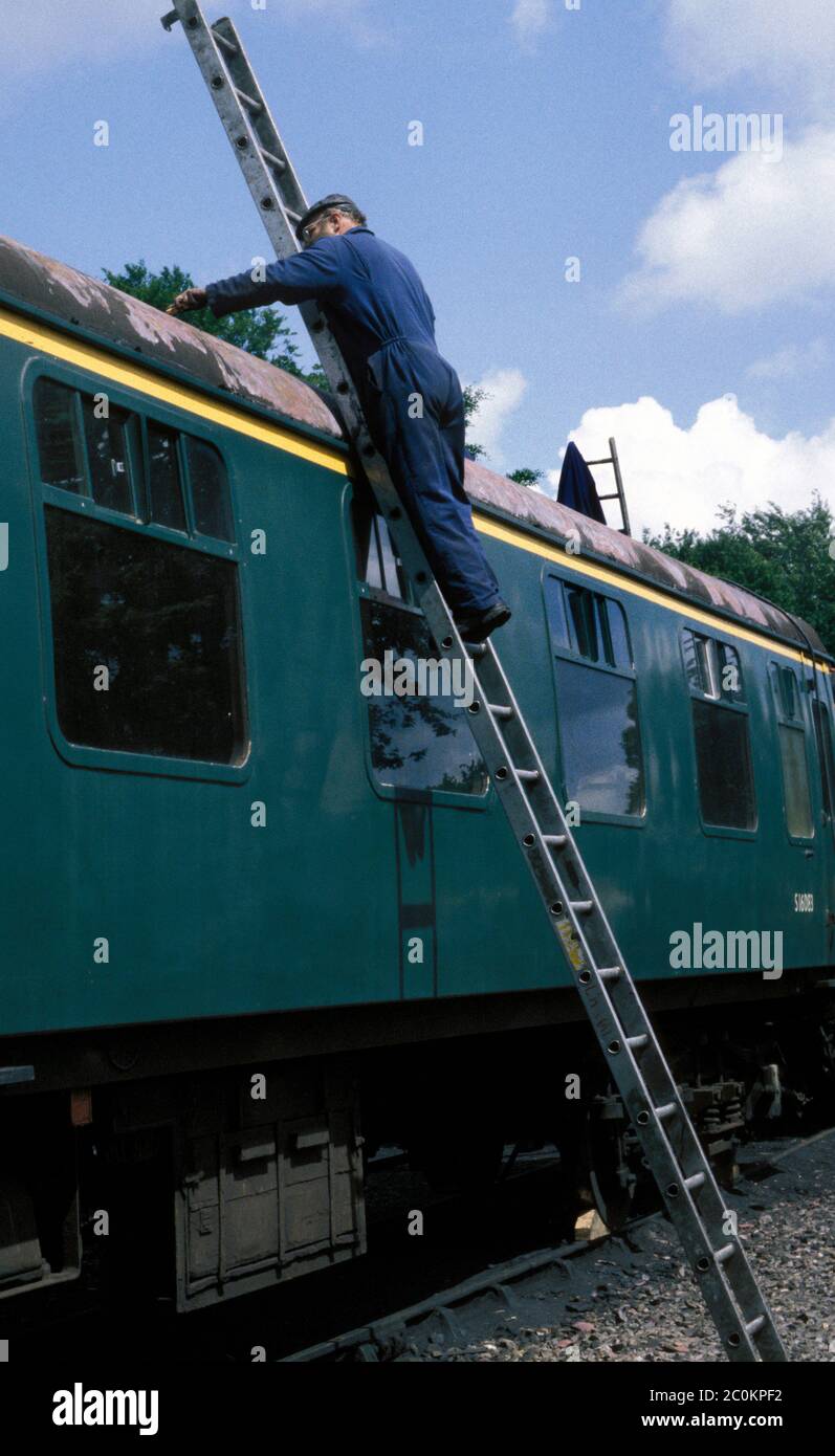 Worker cleaning rail carriage at the North Norfolk railway 'Poppy Line' in Sheringham, UK Stock Photo