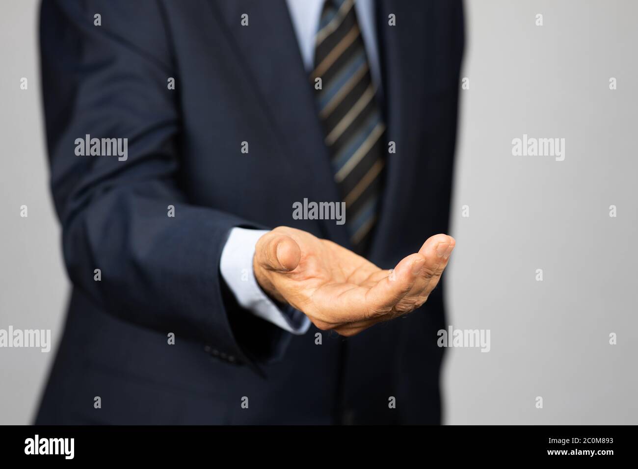 Business man in suit holding an open hand in front of him. Concept for bribery, corruption Stock Photo