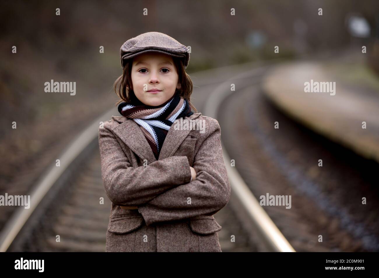 Adorable boy on a railway station, waiting for the train, running and playing Stock Photo