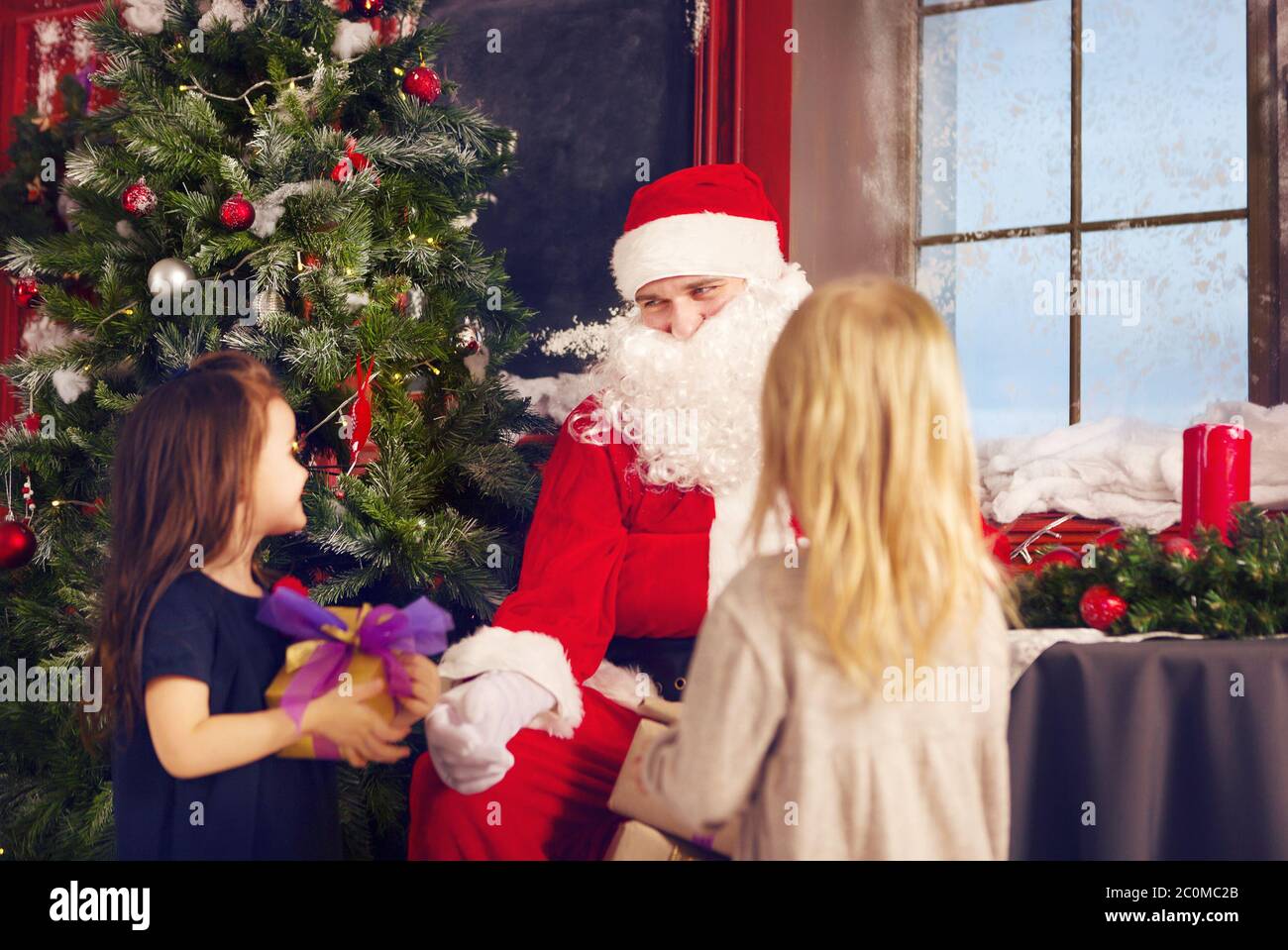 Smiling little girl with Santa Claus and gifts Stock Photo