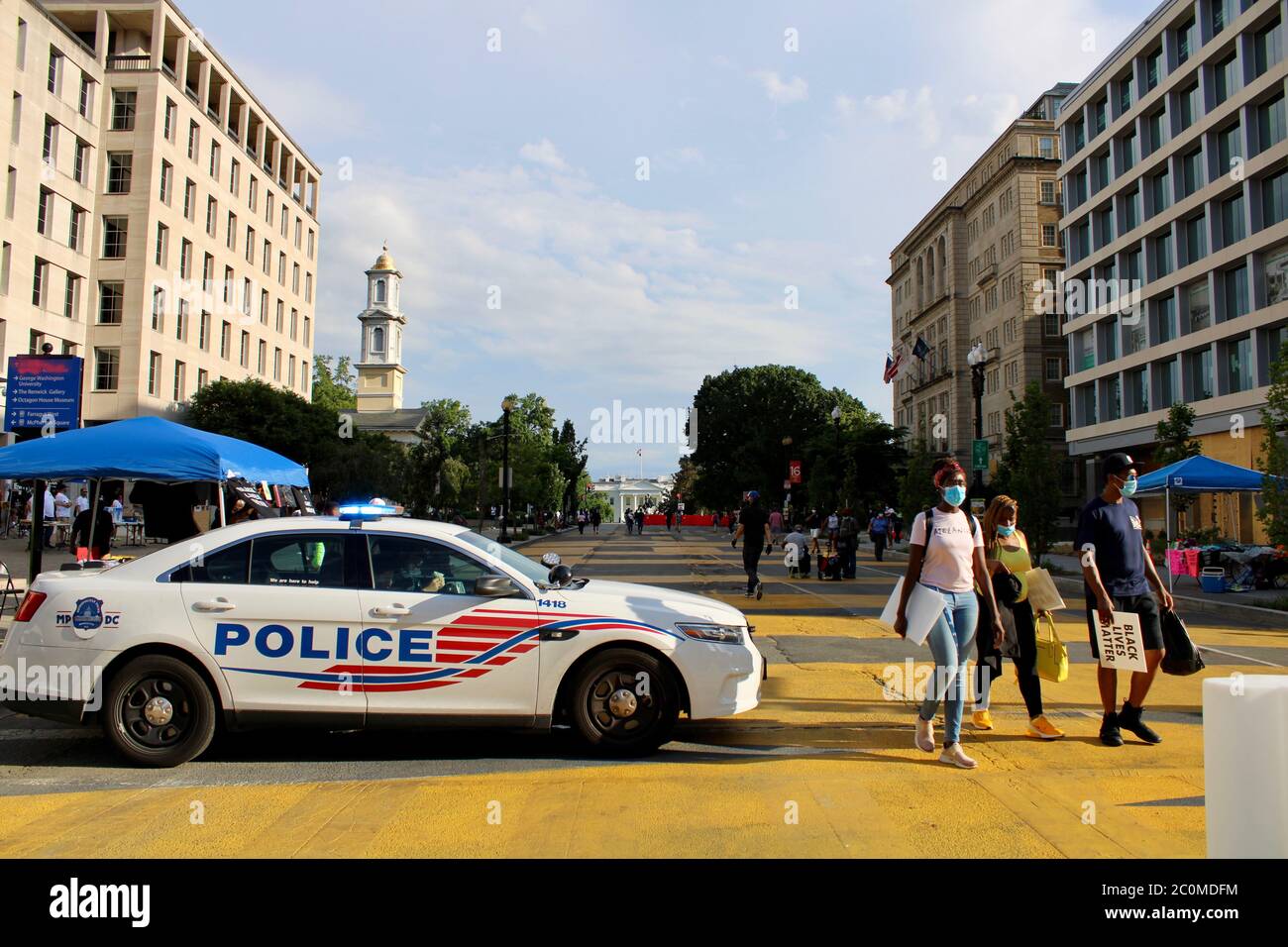 June 11, 2020, Washington D.C, District of Columbia, U.S: We are here to help' sign on Washington, DC Metropolitan Police car, in which sat four men in full riot battle gear with what appears to be assault rifles. Police around the downtown area have appeared alert but relaxed, and have been giving protestors a fair berth of a block or so. Most police officers seen in the area in recent days are African American. Today the fence that President Trump had ordered built around the White House at the start of the George Floyd protests came down, and the Black Lives Matter supporters filled the Stock Photo