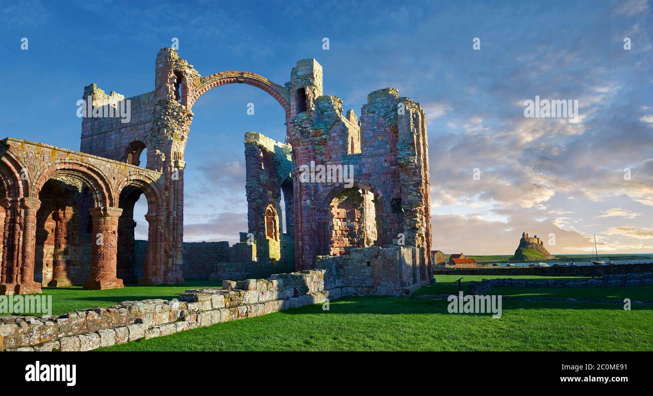 The Anglo Saxon Romanesque Lindisfarne Abbey ruins looking to Lidisfarne Castle,  Holy Island, Lindisfarne, Northumbria, England Stock Photo