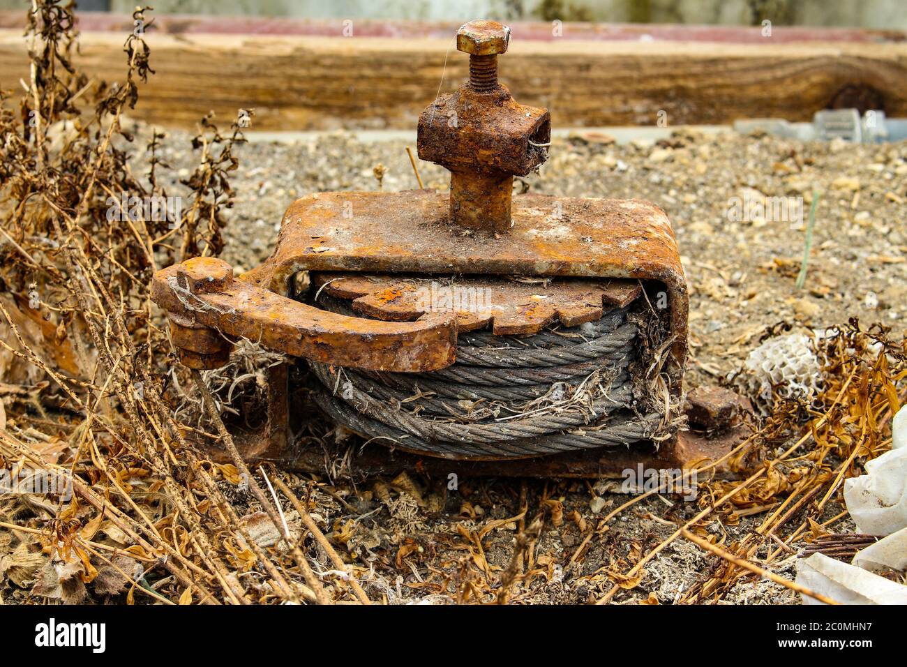 Old rusty winch with ratchet and pawl mechanism and a steel cable
