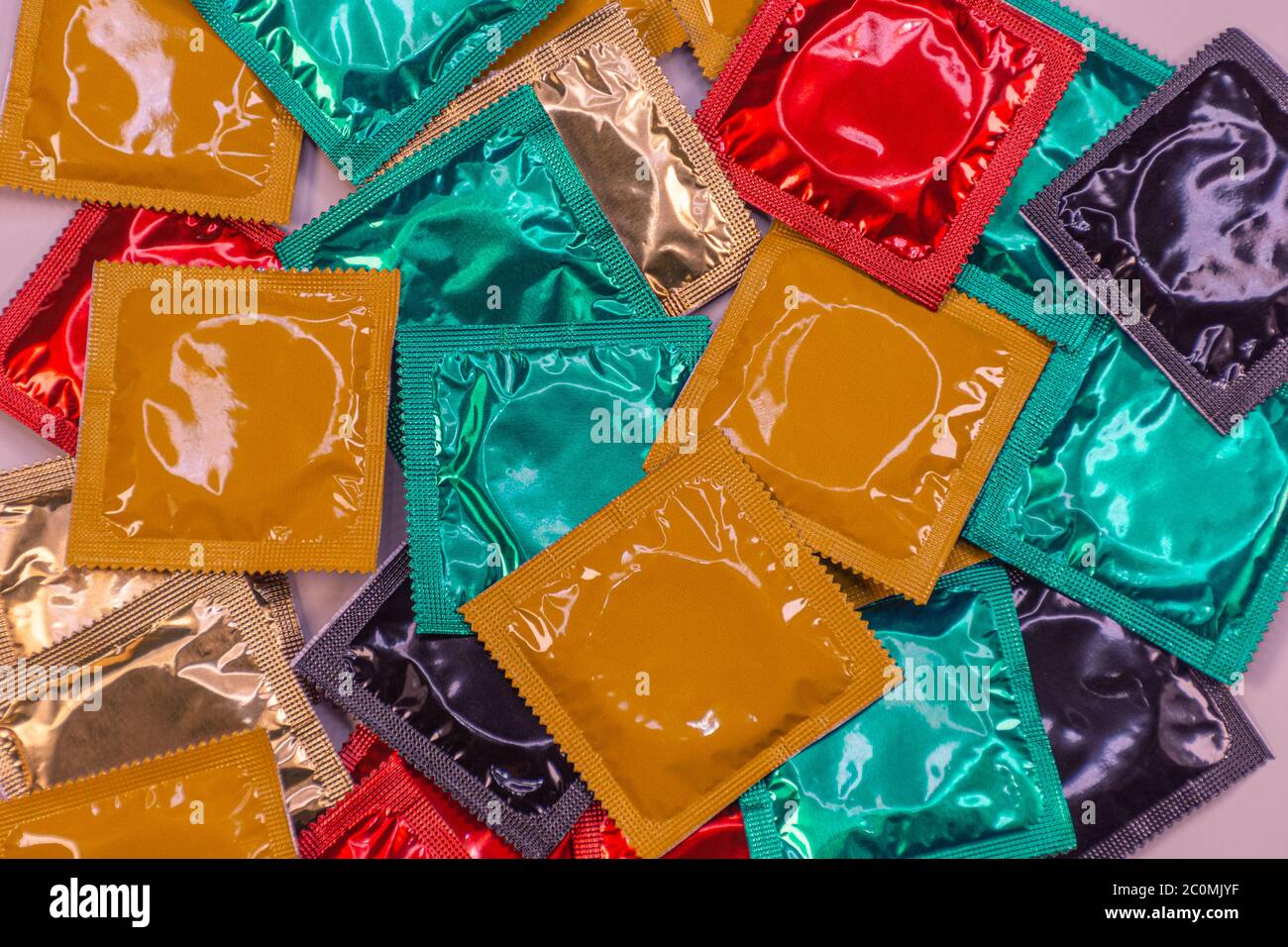 Display of colored condoms on a rotating platform arranged in bulk Stock Photo