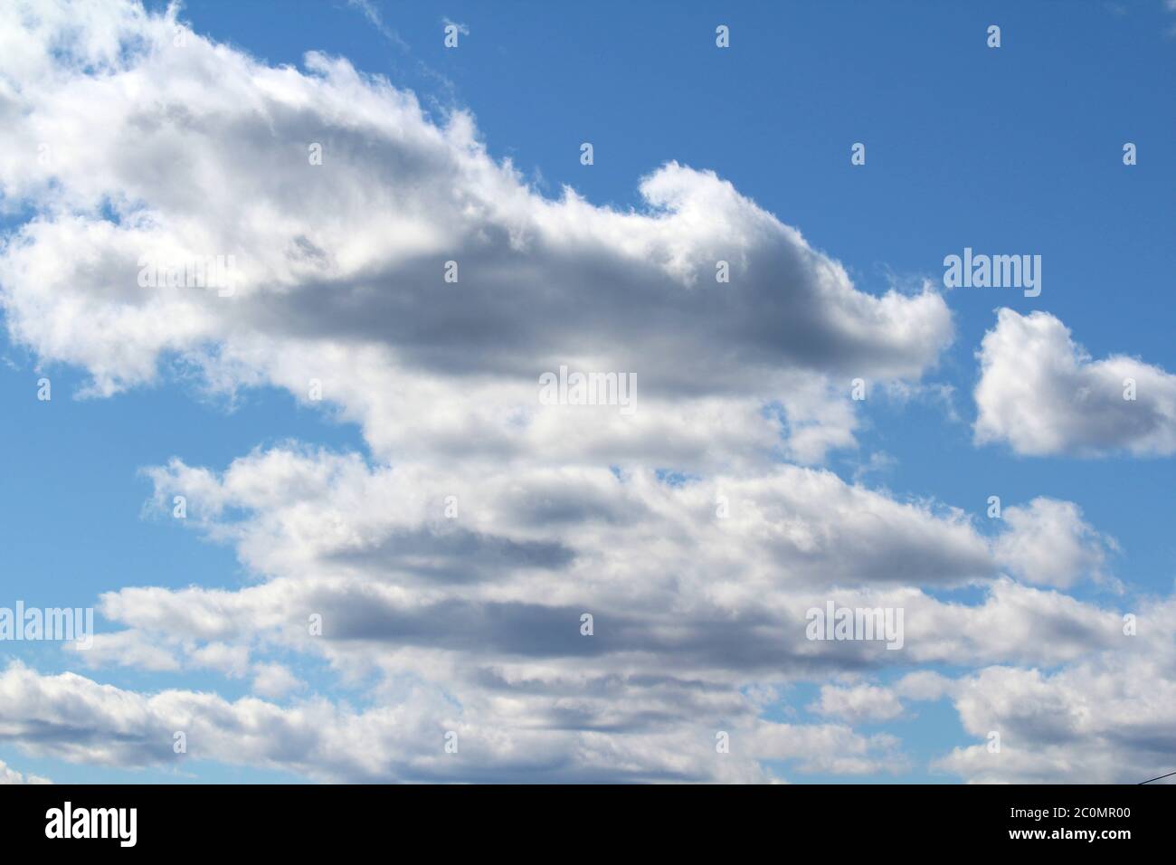 White fluffy clouds on a background of blue sky in summer. The concept ...