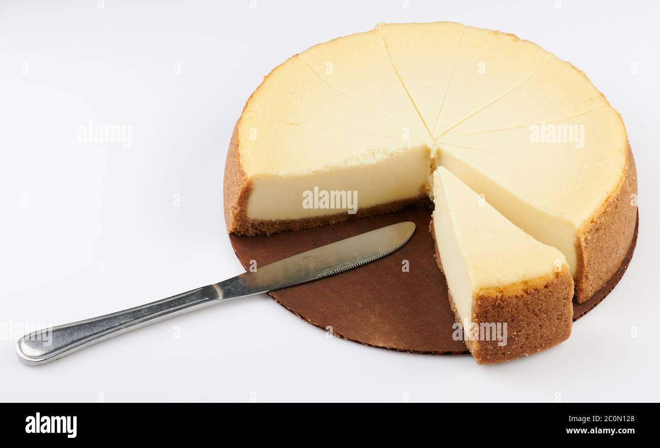 Cutting cheesecake pie with knife isolated on white background Stock Photo