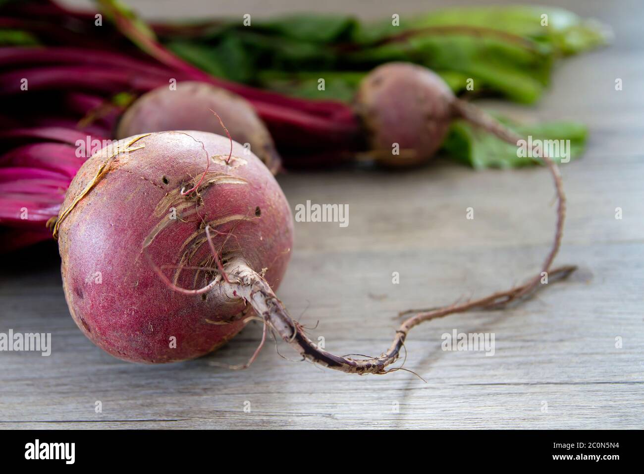 Raw red beetroots on wooden table Stock Photo