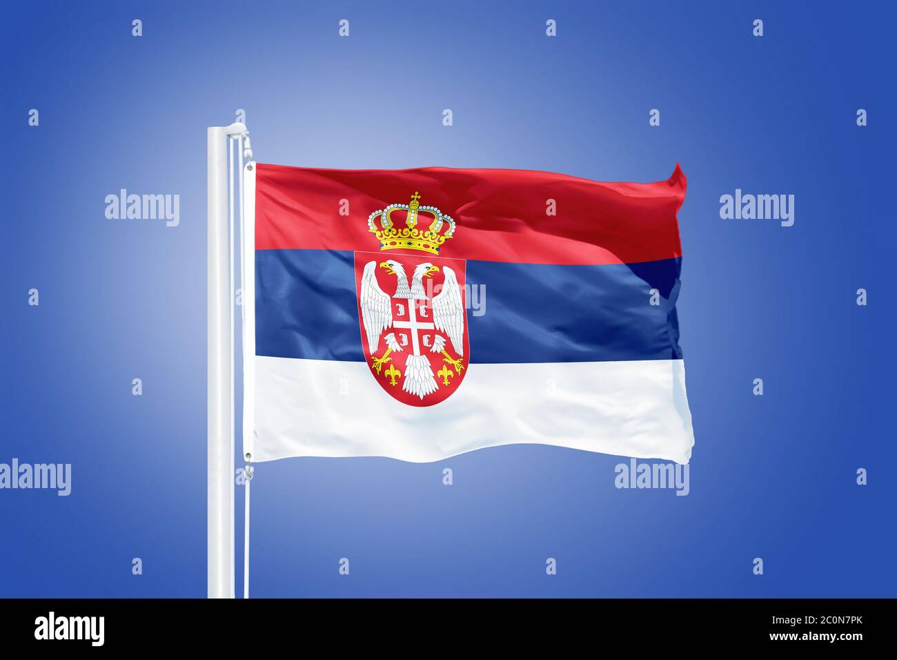 Flag of Serbia flying against a blue sky Stock Photo