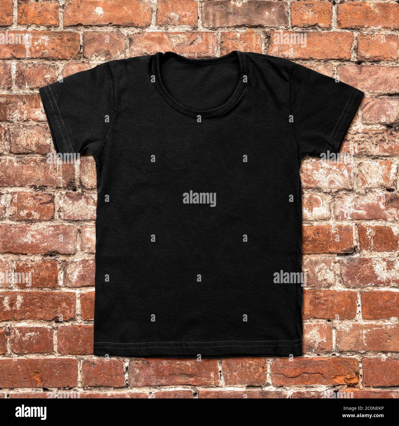 Black blank t-shirt on dark brick background Stock Photo