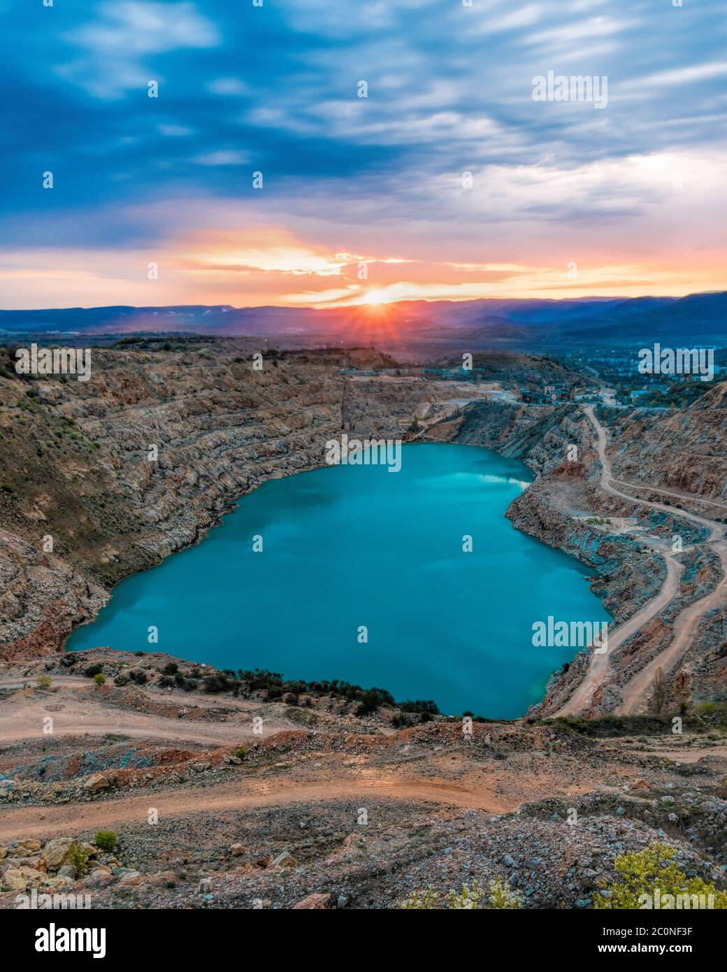 Sunrise over heart shaped blue quarry lake. Fluxing limestone Kadykovsky quarry, Balaklava, Crimea. One of the lowest points of Crimea is in Sevastopo Stock Photo