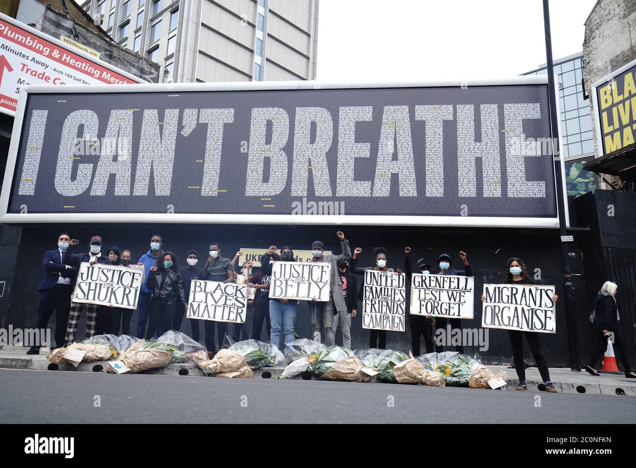 Campaigners at the unveiling of a Black Lives Matter UK (BLMUK) billboard on Westminster Bridge Road, London, which lists more than 3000 names of people who have died in police custody, prisons, immigration detention centres and in racist attacks in the UK, as well as those who have died as the result of coronavirus. The billboard has been erected by BLMUK, in collaboration with the United Families and Friends Campaign, Justice for Belly, Justice for Shukri, Migrants Organise and the Grenfell Estate. Stock Photo