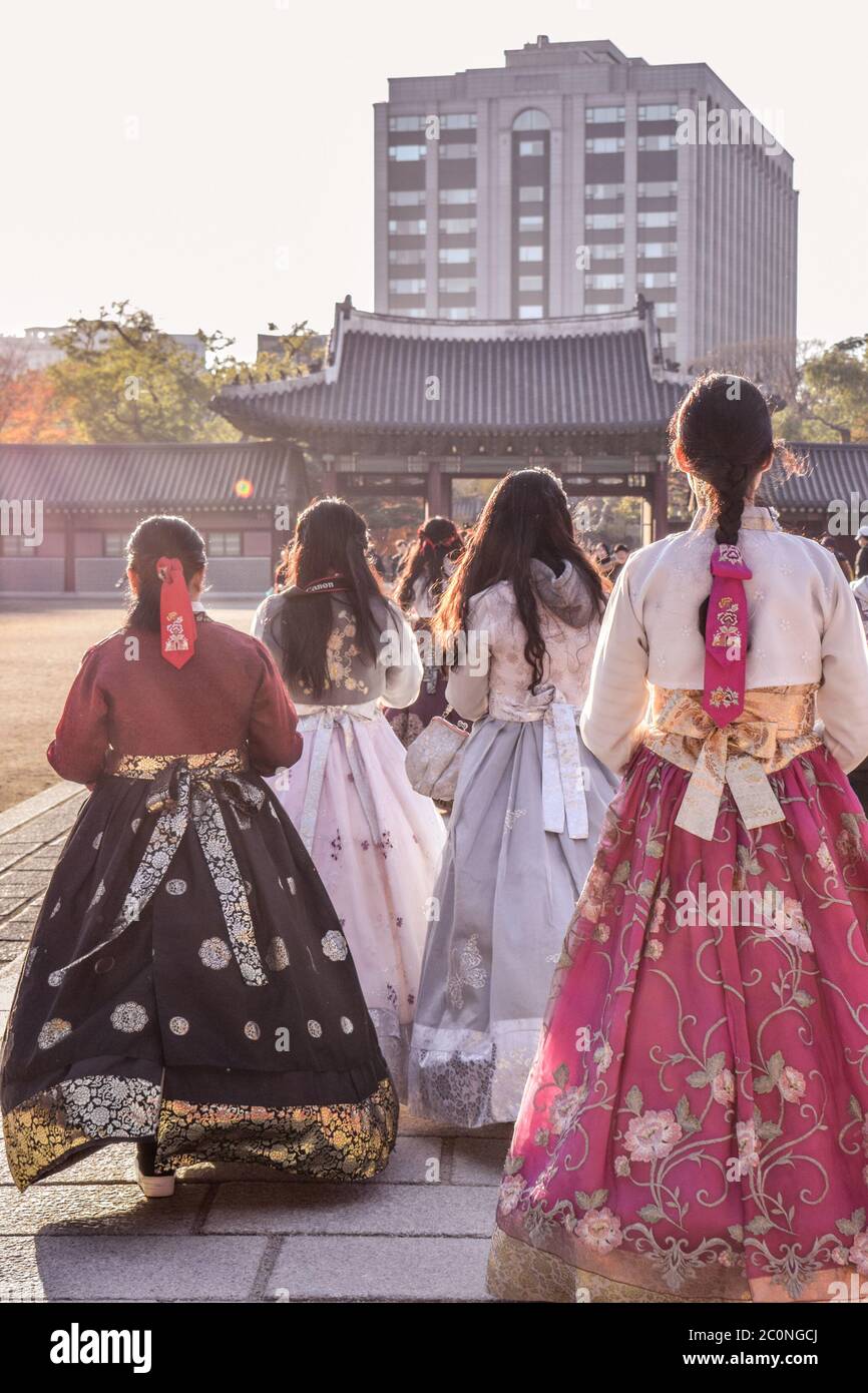 Girls in colorful traditional Korean folklore costumes hanboks walking in Gyeongbokgung palace in Seoul South Korea Stock Photo