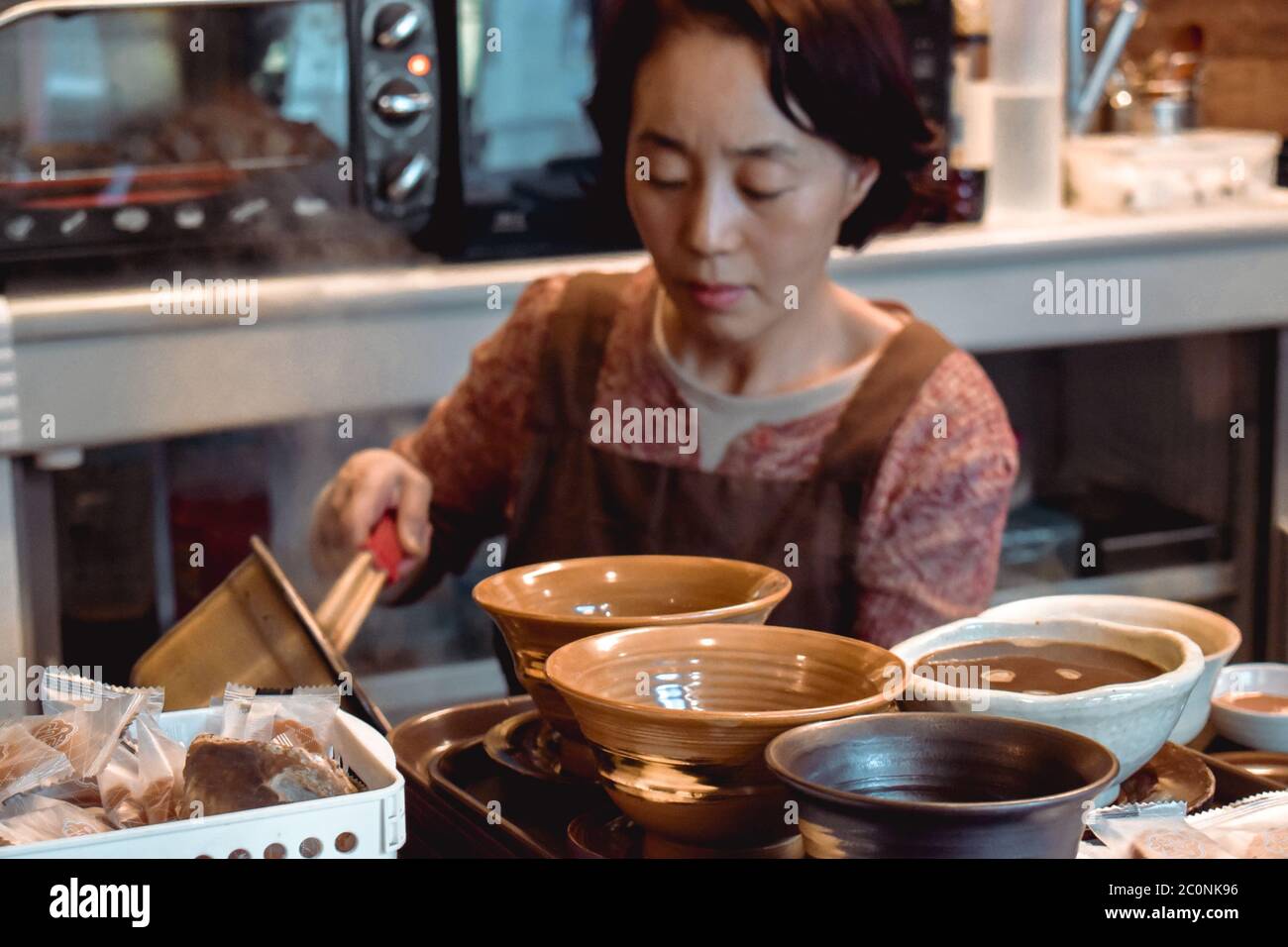Old lady preparing tea the traditional Korean way in the old Insadong street in Seoul South Korea Stock Photo