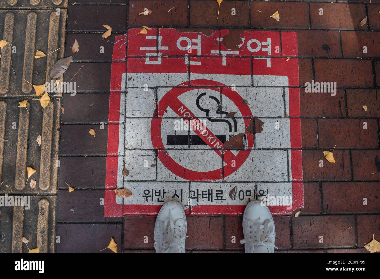 Sneakers standing over no smoking sign autumn Seoul South Korea Stock