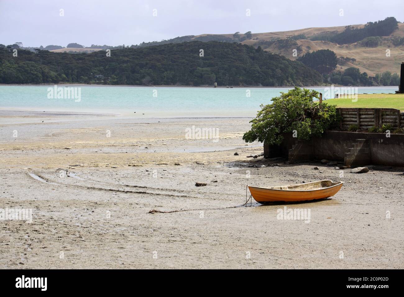 Raglan, beach scene with solitary anchored boat at low tide on Wallis Street. State Highway 23. West Coast North Island, New Zealand. No people Stock Photo