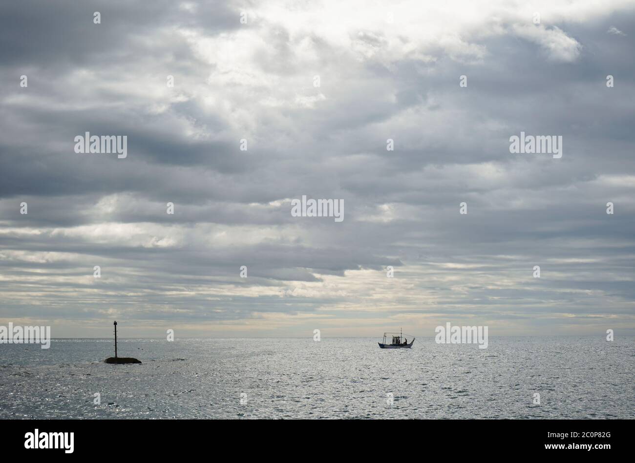 Single alone, small fishing boat at mediterranean sea clouded, Andalusia, Costa del Sol, Spain. Stock Photo