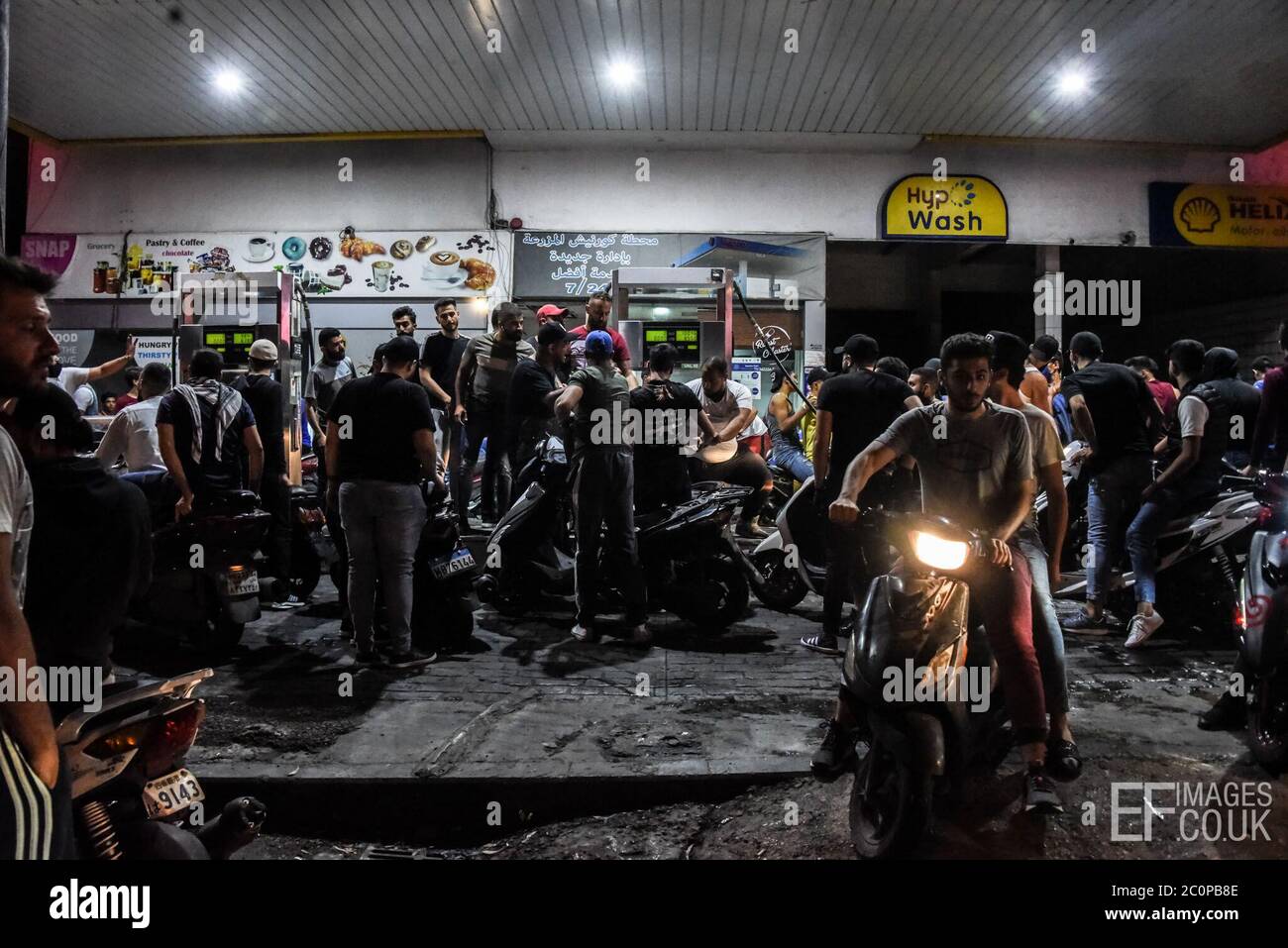 Beirut, Lebanon, 11 June 2020. A moped convoy of protesters stops for gas during rioting in Beirut and across Lebanon, following 25% depreciation of the Lebanese pound in 48 hours. Stock Photo