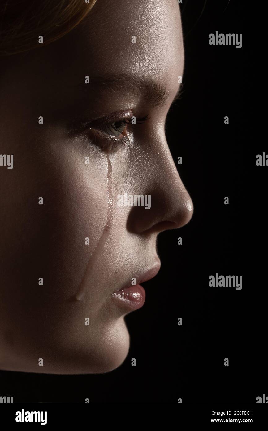 sad woman crying, looking aside on black background, closeup portrait,  profile view Stock Photo - Alamy