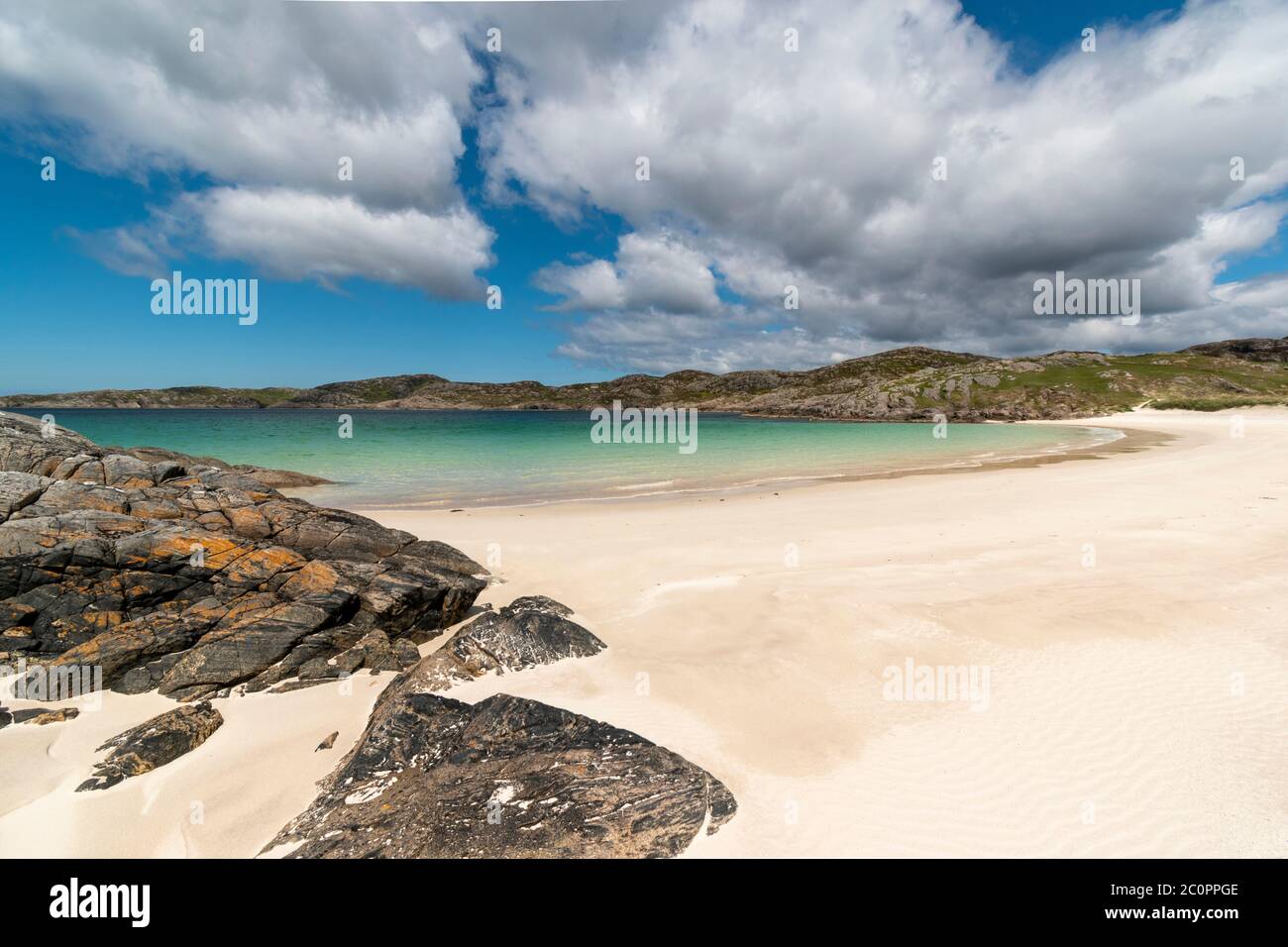 ACHMELVICH BAY AND BEACH SUTHERLAND HIGHLANDS SCOTLAND BLUE  SKY WHITE SAND AND THE COLOURS OF THE SEA Stock Photo
