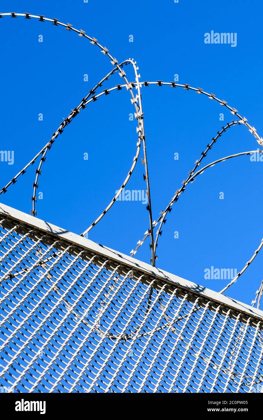 Fence with a barbed wire against the blue sky Stock Photo - Alamy