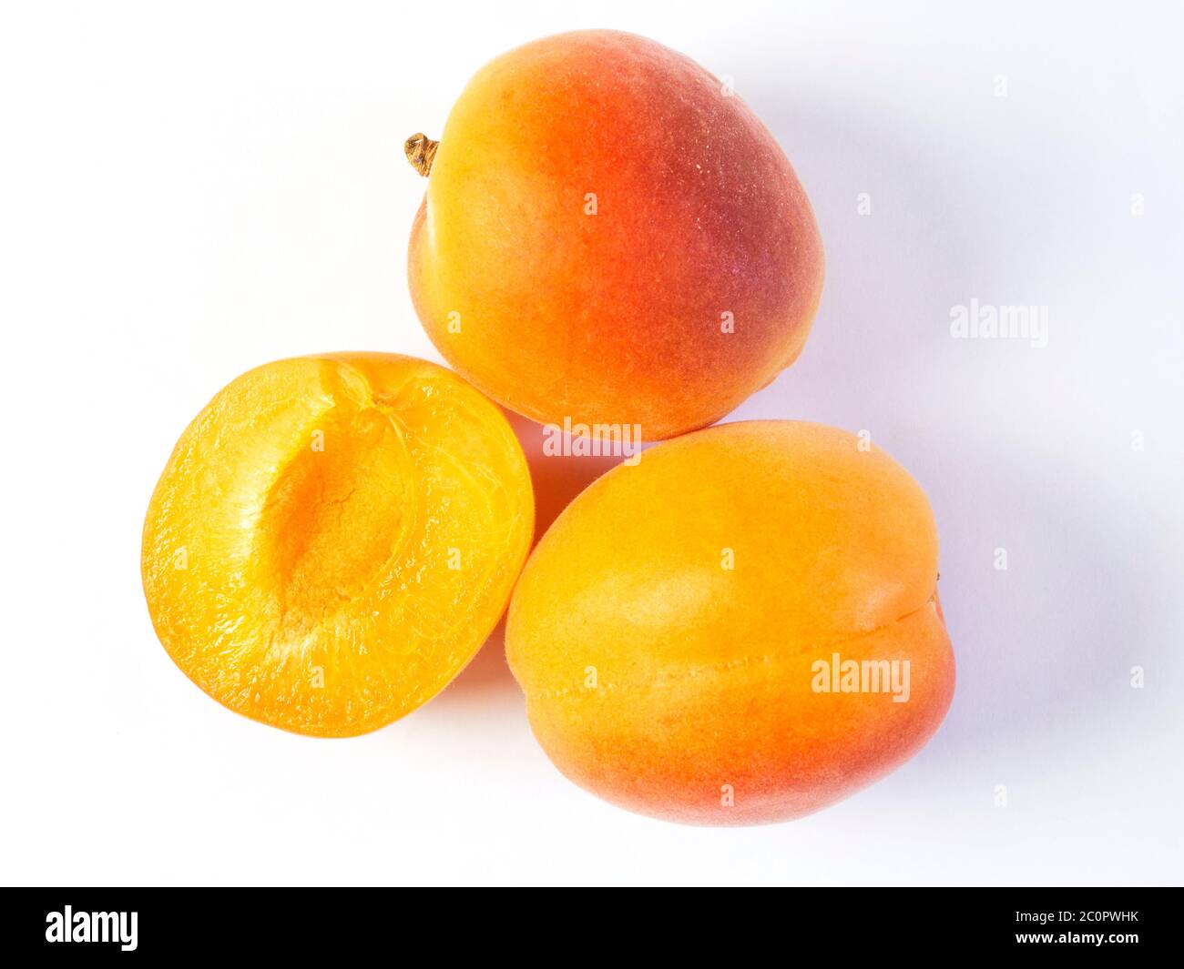 Two whole fresh apricots and a half apricot on a white background Stock Photo Alamy