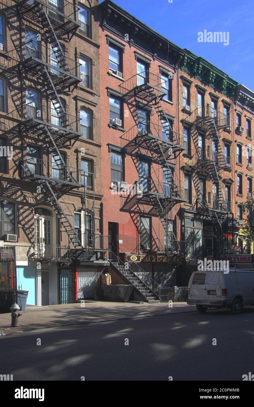 New York City apartment with external fire escape stairs on the front brickwork facade on a summers day in October in Manhattan Stock Photo