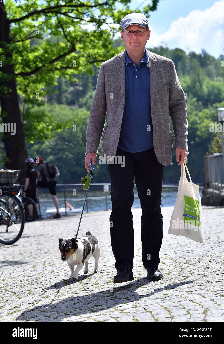 12 June 2020, Thuringia, Saalburg-Ebersdorf: Bodo Ramelow (Die Linke), Minister President of Thuringia, is going into the weekend with dog Attila, after he had previously visited a new e-bike charging station at the Fahrgastschifffahrt Saalburg. Further stations are to follow to boost cycle tourism in the reservoir region known as the 'Sea of Thuringia' at the Bleiloch dam and the Hohenwarte reservoir. Photo: Martin Schutt/dpa-Zentralbild/dpa Stock Photo
